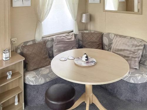 a living room with a table and a couch at Merse Place 57- Uk46905 in Mainsriddle