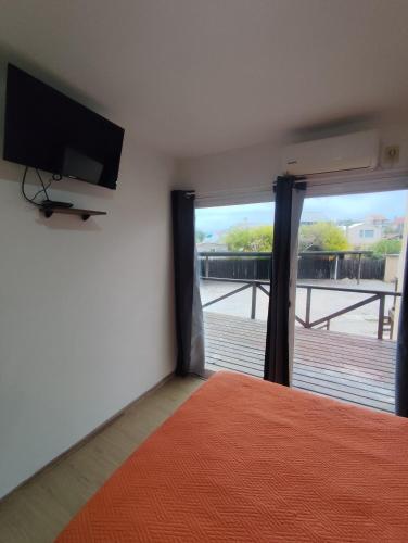a bedroom with a bed and a flat screen tv at Arenas del Diablo in Punta Del Diablo