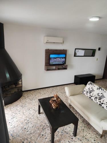 a living room with a couch and a tv at Arenas del Diablo in Punta Del Diablo