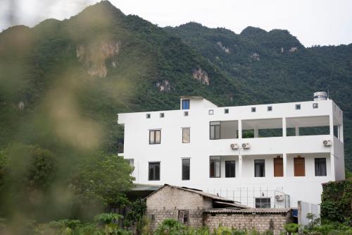 枚州县Bảo An Homestay的山前的白色建筑