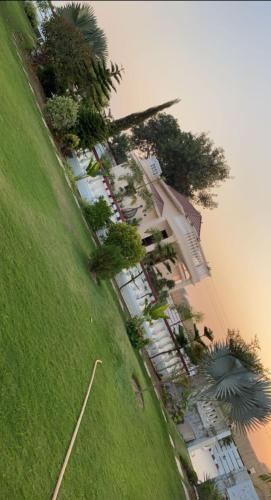 a group of cars parked next to a lawn with trees at Vashistfarmsadhranabamirpur in Gurgaon