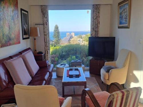 un salon avec un canapé et une télévision dans l'établissement Holiday Home in Perros-Guirec near Beaches, à Perros-Guirec