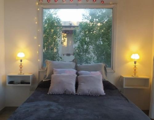 a bedroom with a bed with pillows and a window at Depto 24 Punta Pampa in Las Gaviotas