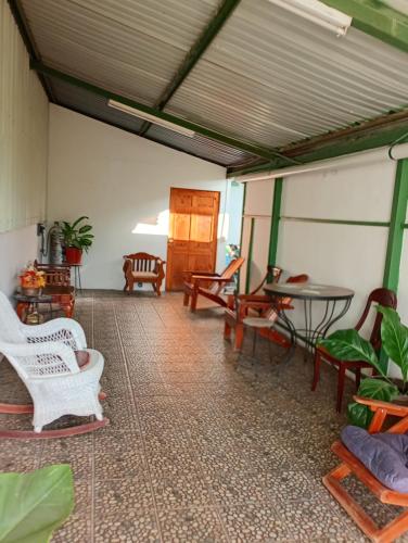 a living room with chairs and tables and a table at Casa Morpho Vacation Home in Liberia in Liberia