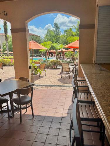 a restaurant with benches and tables and a pool at Awesome Mediterranean Resort! 15 minutes to Disney in Kissimmee