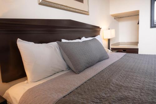 a bedroom with a large bed with white pillows at Hotel America Centro in Los Mochis