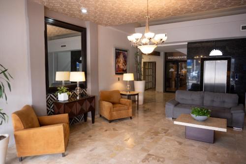 a living room with a couch and chairs and a table at Hotel America Centro in Los Mochis