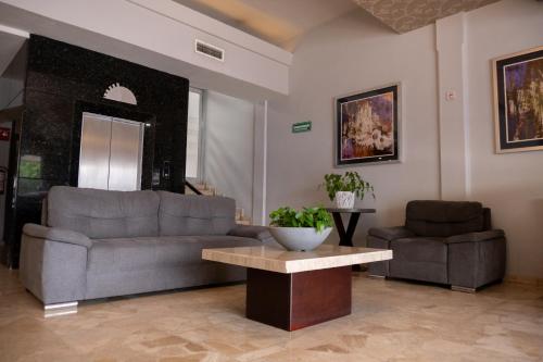 a living room with a couch and a table at Hotel America Centro in Los Mochis