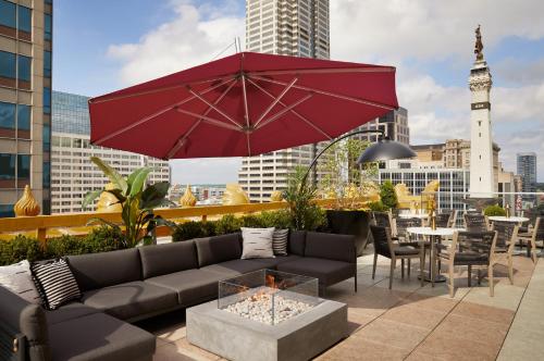 a patio with a couch and a red umbrella at InterContinental Indianapolis by IHG in Indianapolis