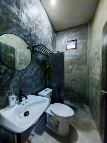 a bathroom with a sink and a toilet and a mirror at KM Pool Spa Resort 
