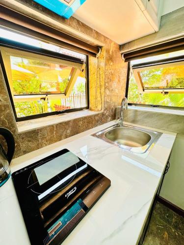 a kitchen with a sink and a microwave on a counter at Laa House in Hoi An