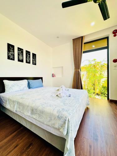 a bedroom with a bed and a large window at Laa House in Hoi An
