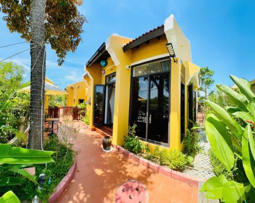 a yellow house with a lot of windows at Laa House in Hoi An