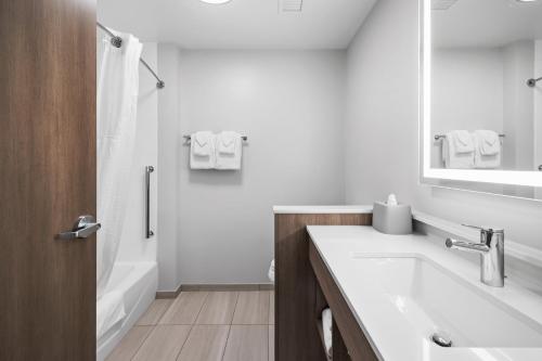 a white bathroom with a sink and a mirror at Holiday Inn Express & Suites Marinette in Marinette