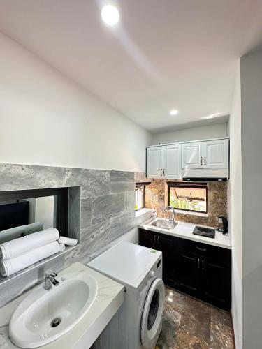 a white bathroom with a sink and a toilet at Laa House in Hoi An