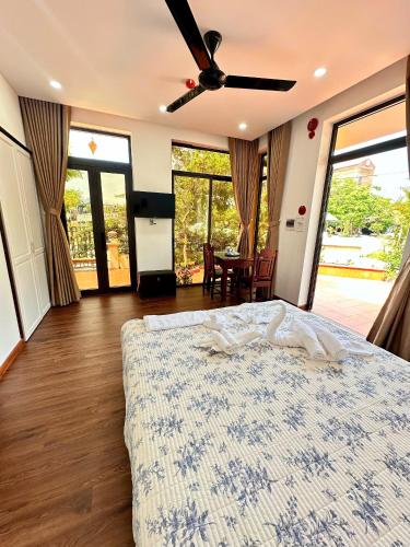 a bedroom with a bed and a table with chairs at Laa House in Hoi An