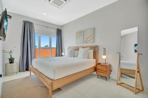 a bedroom with a king sized bed and a balcony at Arubas Life 212 in Noord