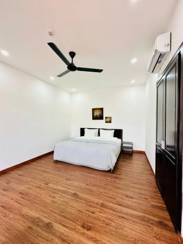 a bedroom with a bed and a ceiling fan at Laa House in Hoi An