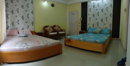 a bedroom with two beds and a bed and chairs at Anna homestay in Dirang Dzong