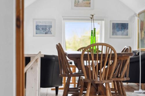 a dining room with a wooden table and chairs at Lovely House With Pool Near Charming Aarhus in Hasselager