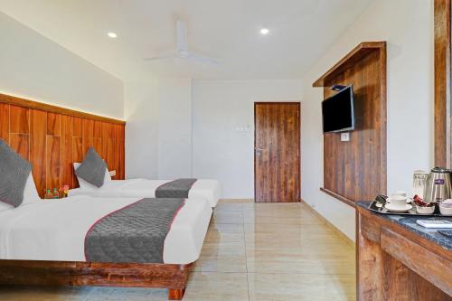 a hotel room with a bed and a television at Townhouse Vandana Residency in Ambernath