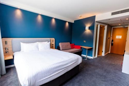 a hotel room with a bed and a chair at Holiday Inn Express Norwich by IHG in Norwich
