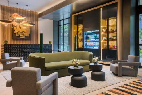 a lobby with a green couch and chairs at Hotel Indigo Lima Miraflores by IHG in Lima