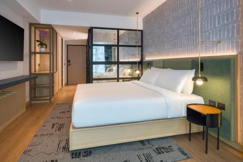a bedroom with a large white bed and a window at Hotel Indigo Lima Miraflores by IHG in Lima