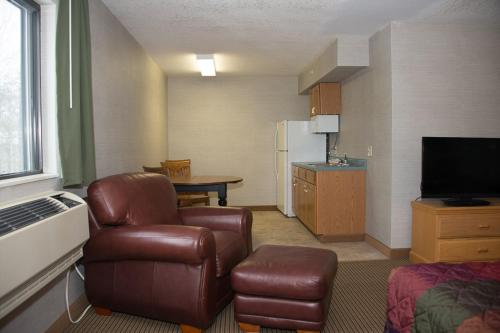 a living room with a couch and a chair and a kitchen at All Seasons Resort in Kalkaska