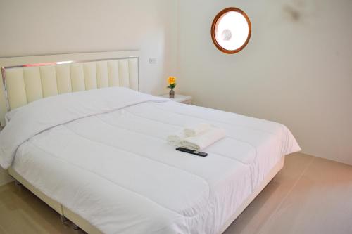a bedroom with a white bed with a clock on the wall at Fandee suites in Ban Sa Kut