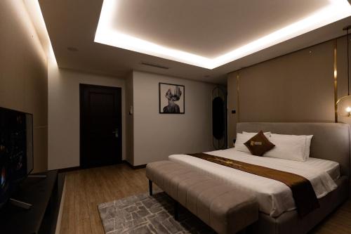 a bedroom with a large bed and a television at Luxhome Mekong Hotel in Can Tho