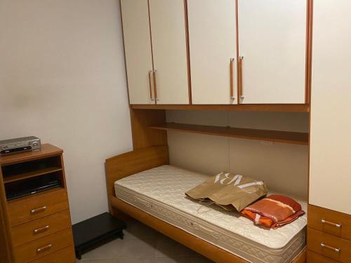 a small room with a small bed with white cabinets at Annina residence in Ravenna