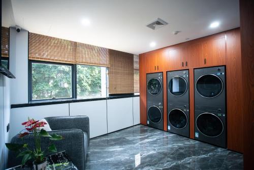 a laundry room with three washer and dryer at Value Comfort Hotel Guangzhou in Guangzhou