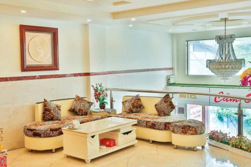 sala de estar con 2 camas y lámpara de araña en Thị Thành Hotel, en Vung Tau