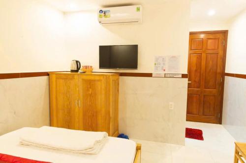 Una habitación con una cama y un televisor en la pared. en Thị Thành Hotel, en Vung Tau
