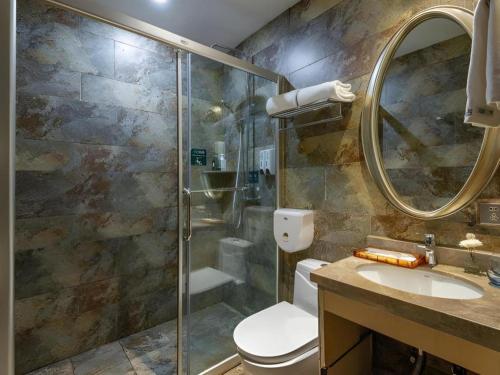 a bathroom with a shower and a toilet and a sink at Leisurely Hotel Shenzhen in Shenzhen