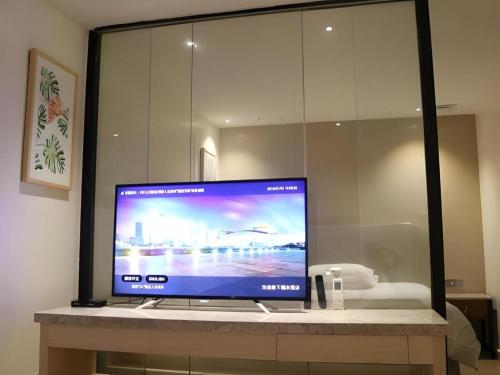 a flat screen tv sitting on top of a counter at Leisurely Hotel Shenzhen in Shenzhen