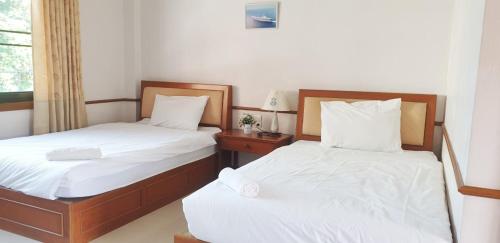 two beds sitting next to each other in a room at NAVY HOME HOTEL โรงแรมเนวี่โฮม in Mae Sai