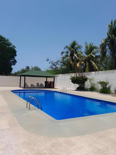 a blue swimming pool with a gazebo at Apartamento con vista al mar in Pampatar
