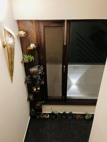 a stairway with a window with potted plants at Casa Kasauli in Kasauli