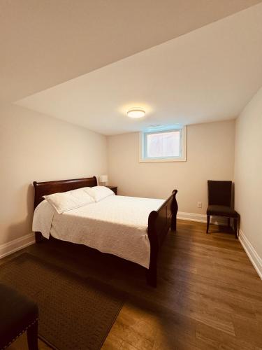 a bedroom with a bed and a chair at 2 Bedroom 1 Parking Basement Unit in Richmond Hill
