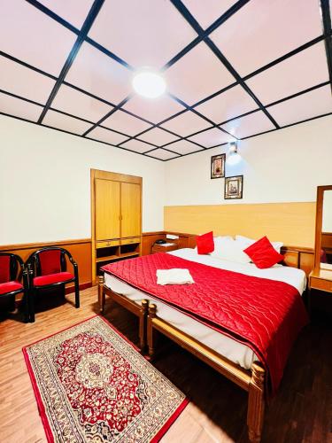 a bedroom with a bed with a red blanket at Abu Residency in Kodaikānāl