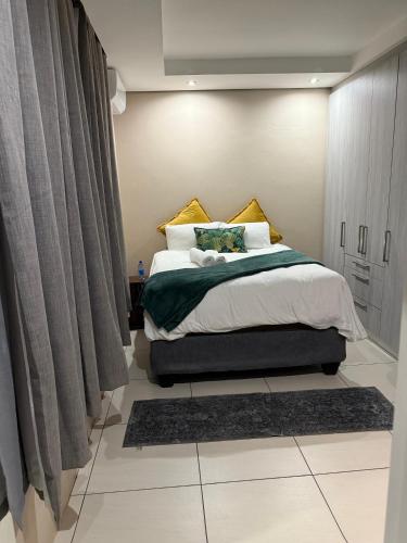 a bedroom with a large bed with curtains and a rug at Cozy Central BNB Mbabane in Mbabane