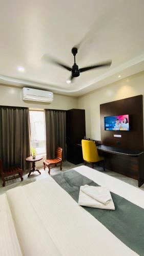 a bedroom with a bed and a desk and a tv at Park Abode Boutique Guest House in Guwahati