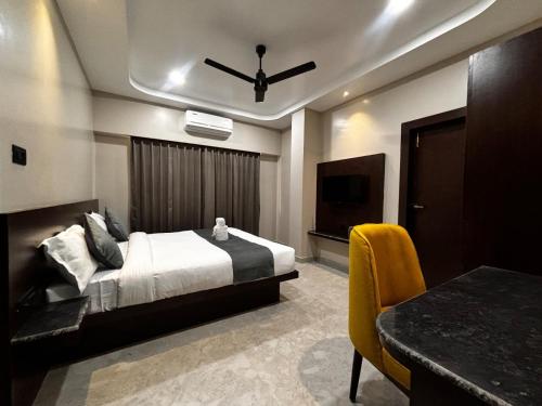 a bedroom with a bed and a television and a table at Park Abode Boutique Guest House in Guwahati