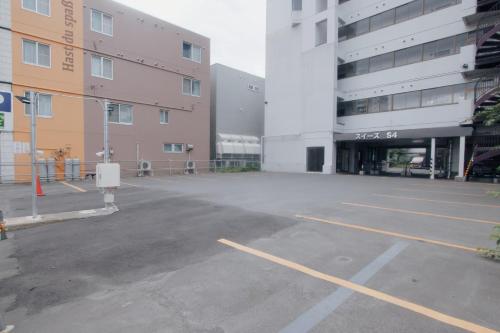 an empty parking lot in front of a building at LikeINN札幌スイーズS4 in Sapporo