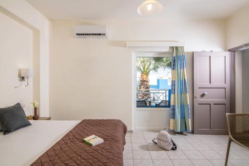 a bedroom with a bed with a book on it at Belvedere Village in Agia Pelagia