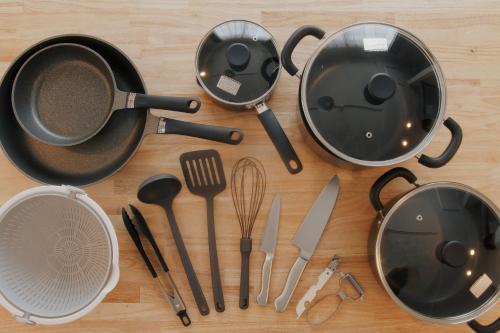 a bunch of kitchen utensils on a wooden table at LikeINN札幌スイーズS4 in Sapporo