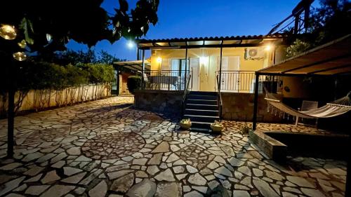 a house with a porch and a hammock in front of it at Mina’s house in Amarinthos