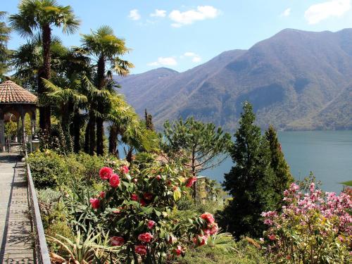 a garden with a view of a lake and mountains at Barony Le Pergole Lugano Villa for 8 persons in Lugano